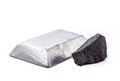 Iron ore on isolated white background next to a polished steel ingot or bar, metals used in the metallurgical industry