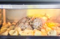 Iron pan in the oven with roasted chicken and potatoes during cooking process Royalty Free Stock Photo