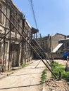 Iron pillars, piles propped up, keep leaning down falling old dangerous dilapidated collapsing house building. Unusual funny