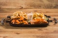 Iron plate of seafood mix with shrimp, fried calamari, french fries and grilled salmon served with lemon  on wooden background Royalty Free Stock Photo