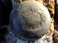 An iron riveted pot used by the Etruscans hanging on a stone pillar Royalty Free Stock Photo