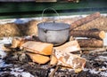 Iron pot on firewood on winter picnic Royalty Free Stock Photo