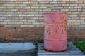 An iron red barrel for storing petroleum products, chemistry stands on a wooden pallet
