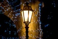 Iron retro lamp post shines with warm light.