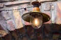 Iron retro lighting lantern with glass shade on brickwork arch. Royalty Free Stock Photo