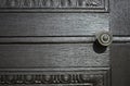 Iron round door handle on wooden dark brown door close up details. Royalty Free Stock Photo