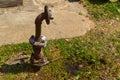 An iron rusty corrosive old industrial water supply pipe for water supply with a flange moving with nuts and studs sticks out Royalty Free Stock Photo