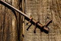Iron rusty stick with old nails over wooden door jamb Royalty Free Stock Photo