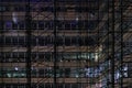 Iron scaffolding construction around steel and glass modern office building in night Royalty Free Stock Photo