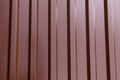 Iron sheet profile corrugated vertical parallel lines brown shiny base industrial background Royalty Free Stock Photo