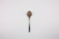 Iron spoon with cocoa powder on a white background