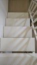 Iron staircase hangings painted white with railing shadows Royalty Free Stock Photo