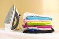 Iron stands with stacks of ironed colored linen. Pile of clothes Royalty Free Stock Photo