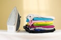 Iron stands with stacks of ironed colored linen. Pile of clothes Royalty Free Stock Photo