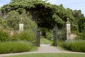 Iron stone wall gate to english garden with big tree