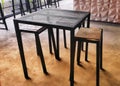 Iron tables and benches combined with wood on a cement floor.