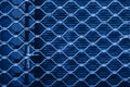 Iron texture of a steel grill on red shutters on the door. Blue background. Royalty Free Stock Photo