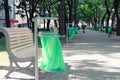 Iron trash can with plastic bag in the city park.