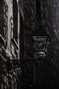 Iron vintage antique style street lantern in the stone medieval wall, spiderweb in the lantern, Spain Royalty Free Stock Photo