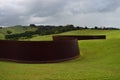 Iron wave, huge wall over farmland, hills, art landscape, New Zealand