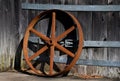 Iron Wheel Stands Rusting Against Wooden Building Royalty Free Stock Photo