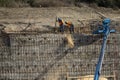 Iron workers shoveling dirt on wall of rebar and steel beams on freeway construction project Royalty Free Stock Photo