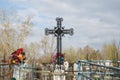 Iron wrought cross among the graves at Troitskoye cemetery 1842 in the Krasnoyarsk city, in the spring.