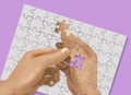 IRONIC JIGSAW PUZZLE-A puzzle of a hand holding a puzzle pieces is completed by an identical hand holding the last piece of the Royalty Free Stock Photo