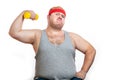 Fat funny man in red headband shows his muscles with dummbell and emotions Royalty Free Stock Photo