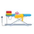 Ironing board with clothes stack and electric iron Royalty Free Stock Photo