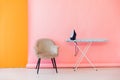 Ironing board and iron in pink orange room interior Royalty Free Stock Photo