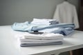 Ironing, laundry, clothes, housekeeping and objects concept - close up of ironed and folded shirts on table Royalty Free Stock Photo