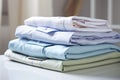 Ironing, laundry, clothes, housekeeping and objects concept - close up of ironed and folded shirts on table