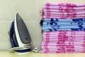 Ironing linen with steam generator. A stack of ironed towels lying next to the iron. Teflon sole plate covered with small holes. Royalty Free Stock Photo