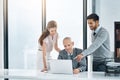 Ironing out the details. three businesspeople using a laptop in the office. Royalty Free Stock Photo