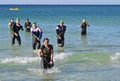 Ironman competitors exit ocean in Panama City Beach, Florida.