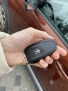 IRPEN, UKRAINE, NOVEMBER 23 20222, Peugeot 3008 car key in a woman's hand with a car in the background