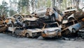 Irpin, a lot of burned-out shelled cars in the parking lot on top of each other in the middle of the forest, the