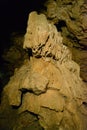 irregular stalagmite in a dark cave