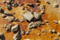 Irregular stones on the reddish earthen floor, background concept or texture