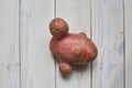 Irregularly shaped potatoes on a white wooden background. Food waste and ugly food concept Royalty Free Stock Photo