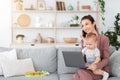 Irresponsible Babysitter. Young Nanny Talking On Cellphone And Ignoring Baby Using Laptop