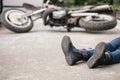 Irresponsible motorcyclist lying on the road and motorbike in th Royalty Free Stock Photo