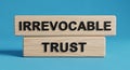 Irrevocable trust concept displayed on wooden blocks against a blue background in a studio setting Royalty Free Stock Photo
