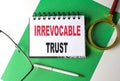 IRREVOCABLE TRUST text on notebook on green paper