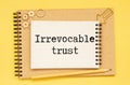 IRREVOCABLE TRUST text on sticker with pen on the black background