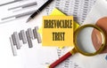 IRREVOCABLE TRUST text on a sticky on the graph background with pen and magnifier