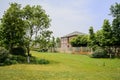 Irrigated lawn before fenced house in sunny summer