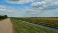 irrigation canal along a field and an empty dirt road. Reclamation channel for improving hydrological, soil and agro-climatic