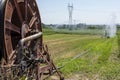 Irrigation equipment with the automatic winding mecanism in foreground spreading water over a field Royalty Free Stock Photo